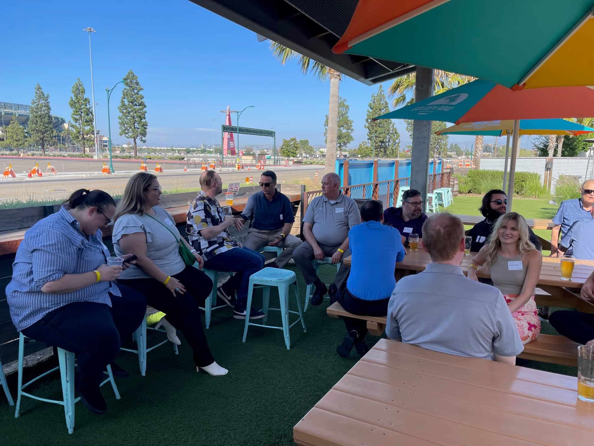 Orange County and Denver team members sitting around in the shade outside. 