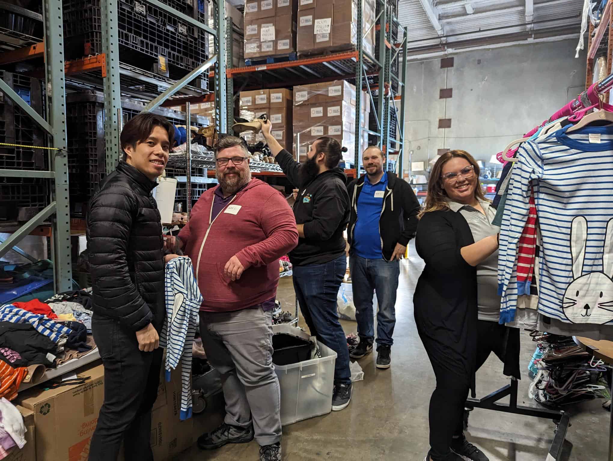 Group of people sorting out clothes in a warehouse